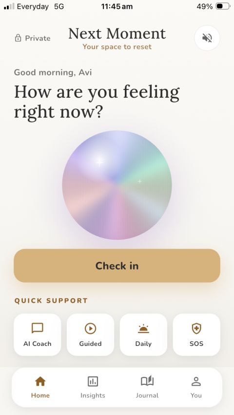 The Next Moment app home screen: 'Good morning, Avi — How are you feeling right now?' above a soft glowing orb, a gold 'Check in' button, and Quick Support shortcuts for AI Coach, Guided, Daily, and SOS.